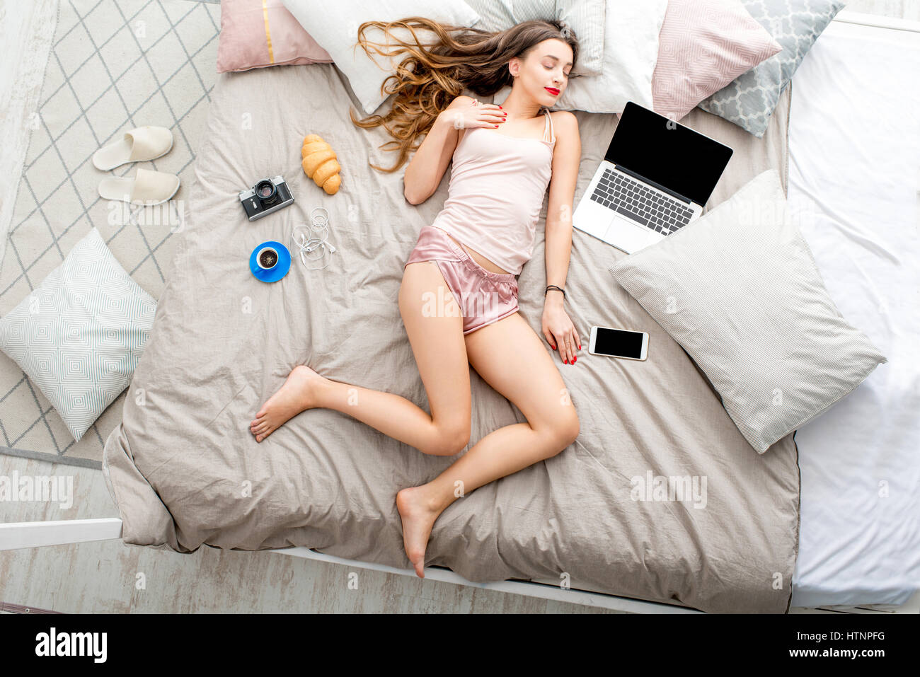 Donna sul letto con il computer portatile Foto Stock