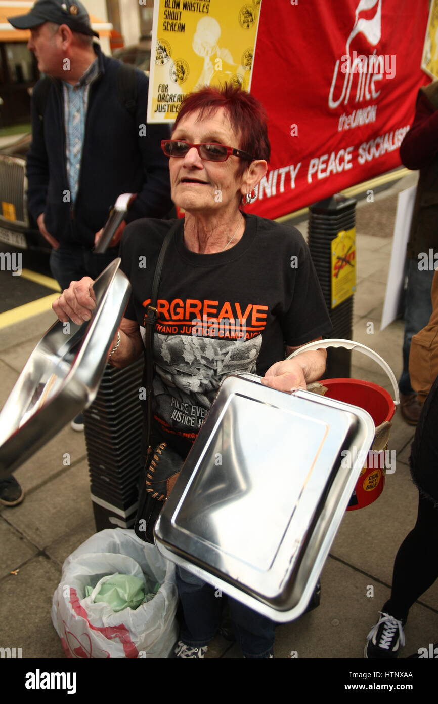 Westminster, Londra, Regno Unito 13 marzo 2017.Una donna bangs due vassoi di supporto insieme come manifestanti dal Orgreave verità e giustizia campagna tenere una protesta rumorosa fuori casa ufficio edificio. La campagna è esigente un'indagine eventi durante il minatore della sciopero quando la polizia ha attaccato i minatori di picchetti di Orgreave cokeria. Roland Ravenhill/Alamy Live News Foto Stock