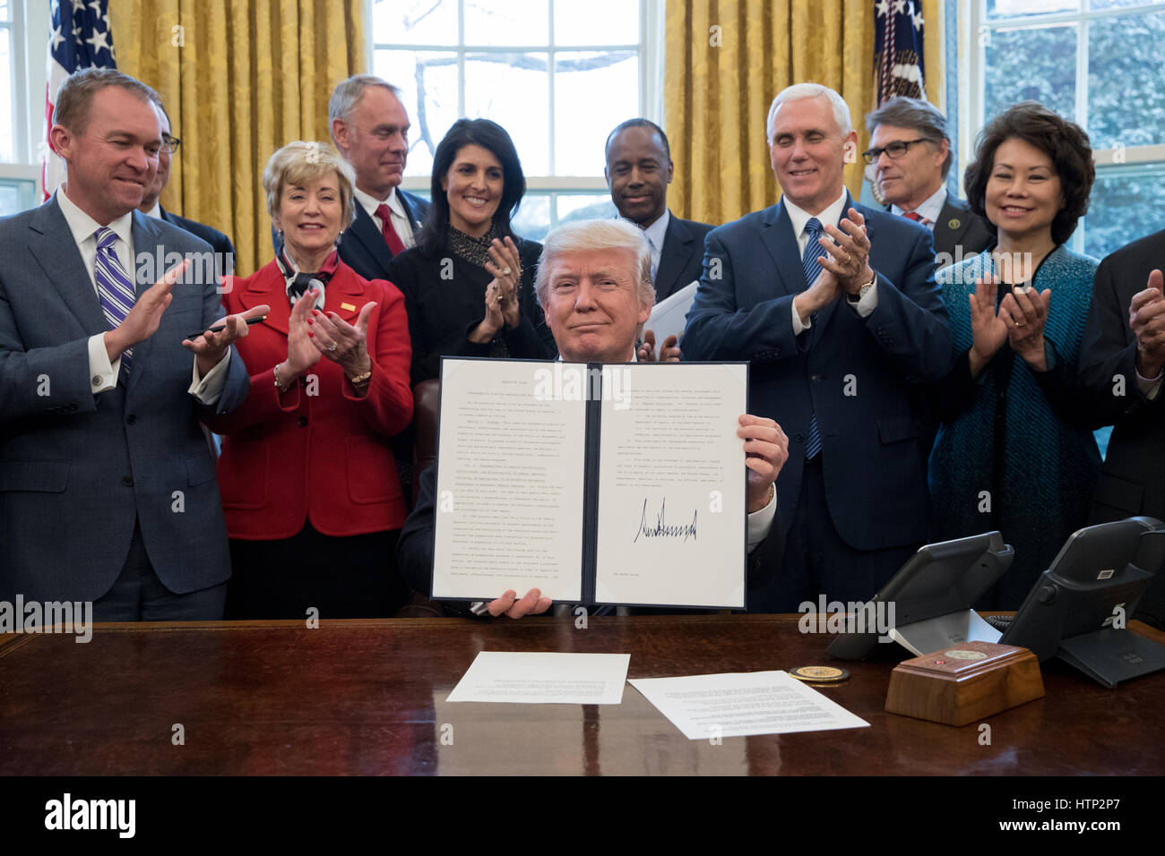 Washington DC, USA, 13 marzo, 2017 Il presidente statunitense Donald Trump J (C) mostra un ordine esecutivo intitolata, "Piano globale per riorganizzare il ramo esecutivo', dopo la firma accanto a membri del suo gabinetto all Ufficio Ovale della Casa Bianca nel lavare Foto Stock
