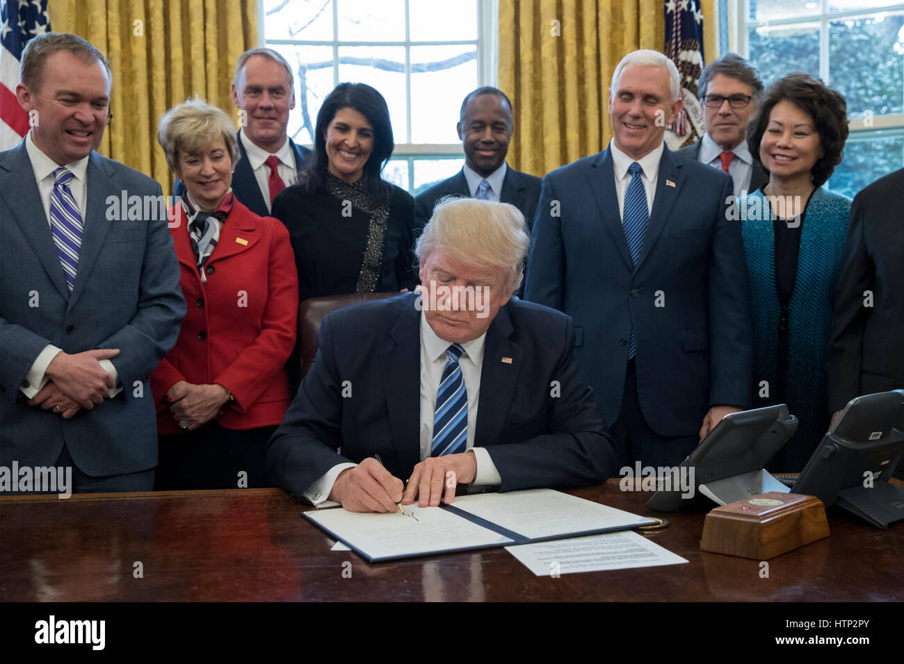 Washington DC, USA, 13 marzo, 2017 Il presidente statunitense Donald Trump J (C) firma un ordine esecutivo intitolata, "Piano globale per riorganizzare il ramo esecutivo', accanto a membri del suo gabinetto all Ufficio Ovale della Casa Bianca di Washington, DC, STATI UNITI D'AMERICA, Foto Stock