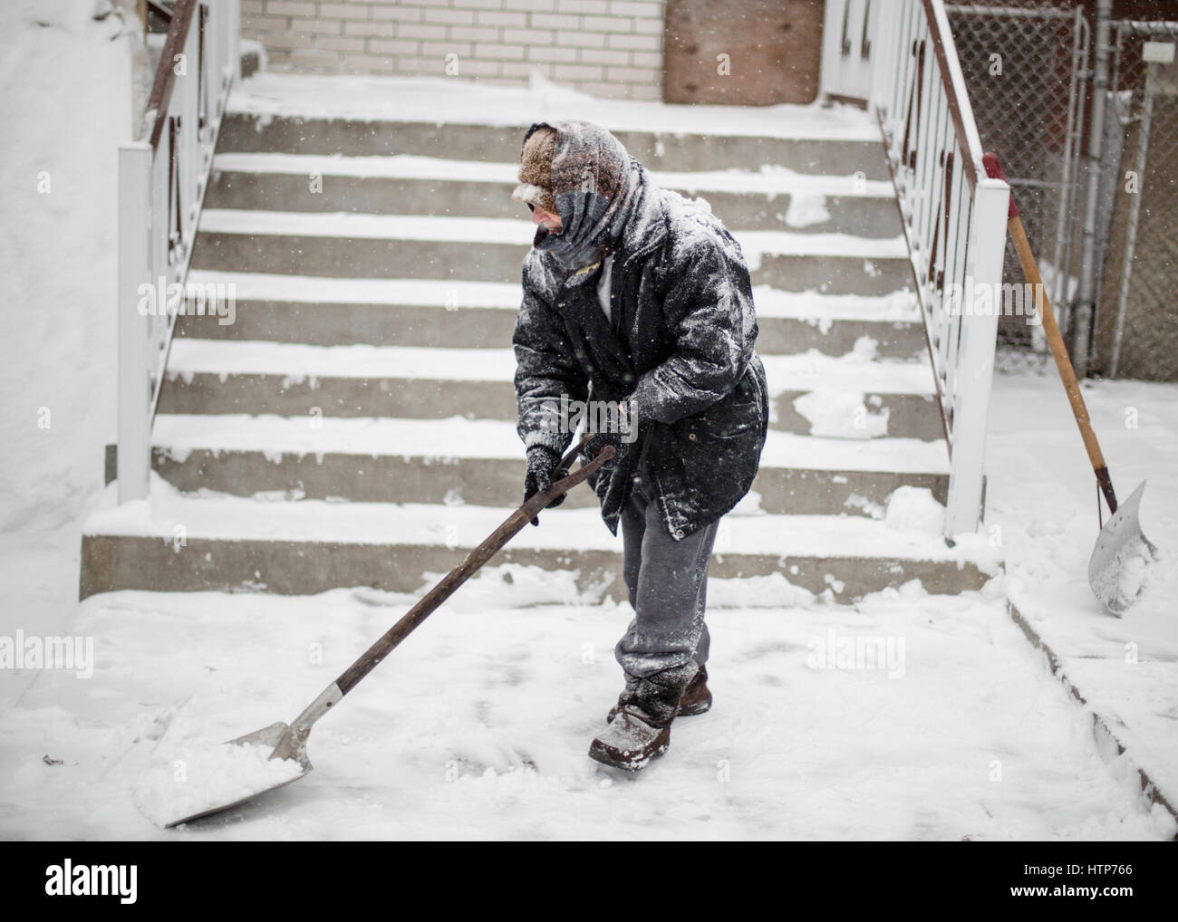 Montreal, Canada. Xiv Mar, 2017. Montreal, Quebec. Marzo 14th, 2017. Una donna anziana pale da neve la parte anteriore della sua casa. La tempesta di neve che sta colpendo orientale del Canada e degli Stati Uniti, è atteso a goccia 15-25 centimetri di neve nella regione di Montreal. Credito: Dario Ayala/Alamy Live News Foto Stock