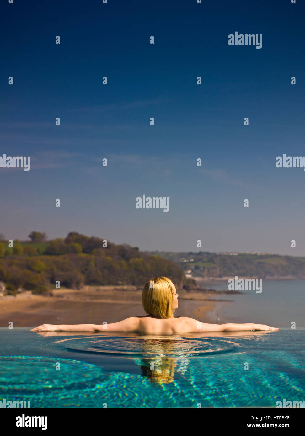 Giovane donna rilassante nella piscina infinity, St.Brides Spa Hotel, Saundersfoot, Pembrokeshire, Galles, Gran Bretagna Foto Stock
