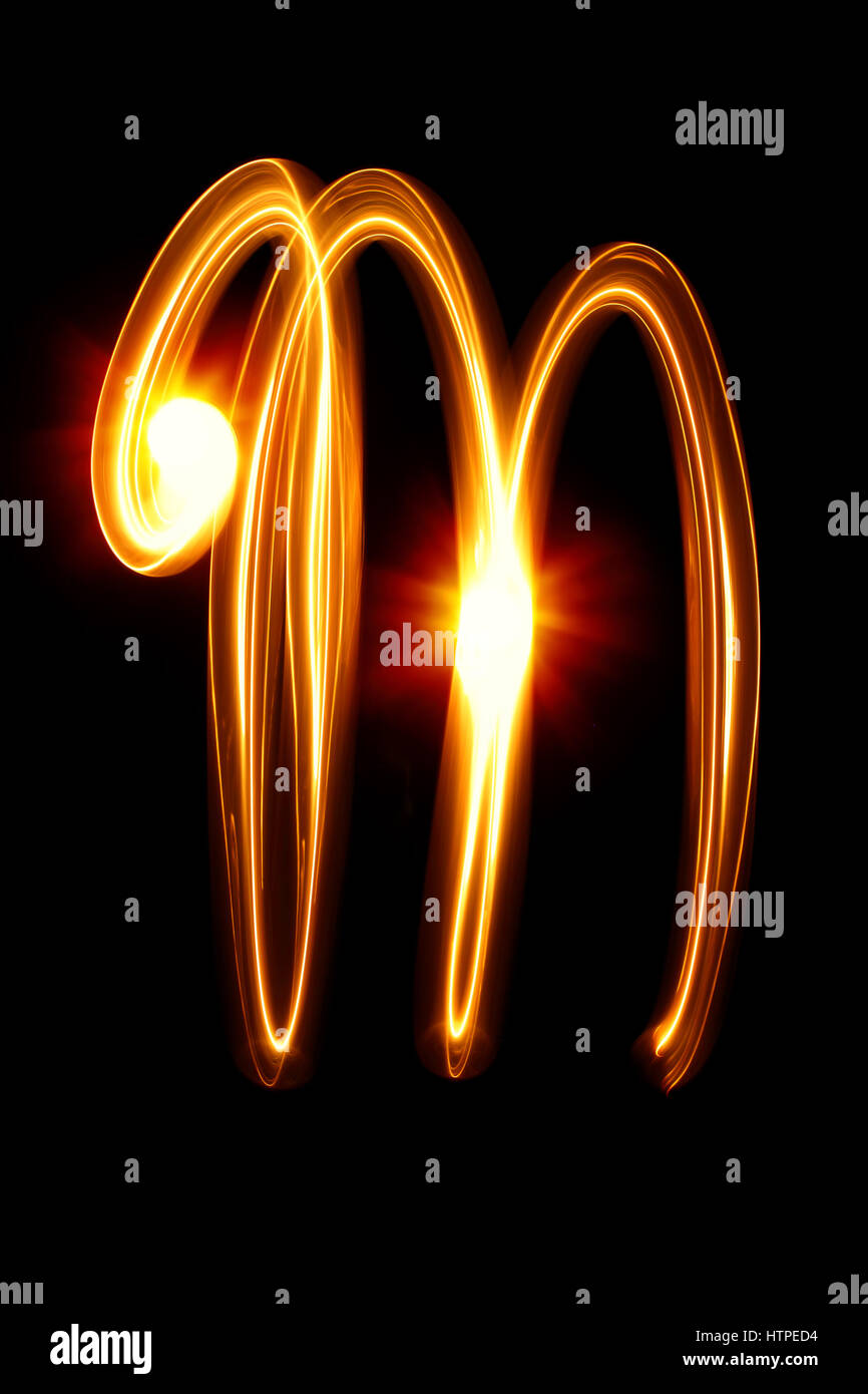 M - creato da alfabeto di luce su sfondo nero Foto Stock