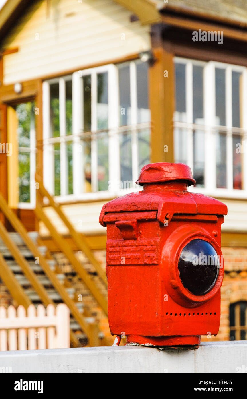 Spia di avvertimento su un livello gated incrocio con Wansford casella segnale in background Foto Stock