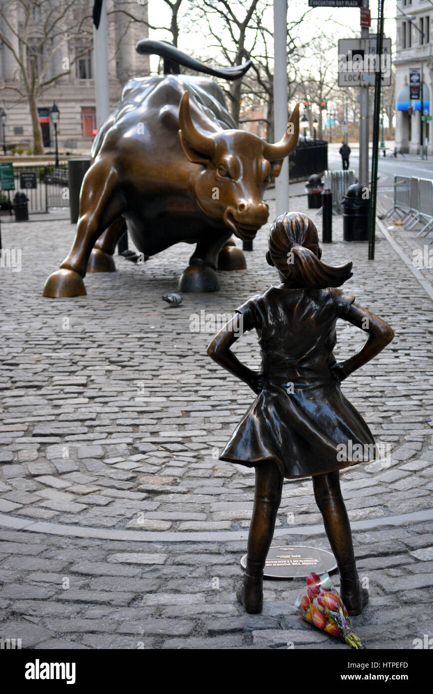 'L'impavido Girl' statua rivolta verso il toro di carica su Broadway in Manhattan inferiore. Foto Stock