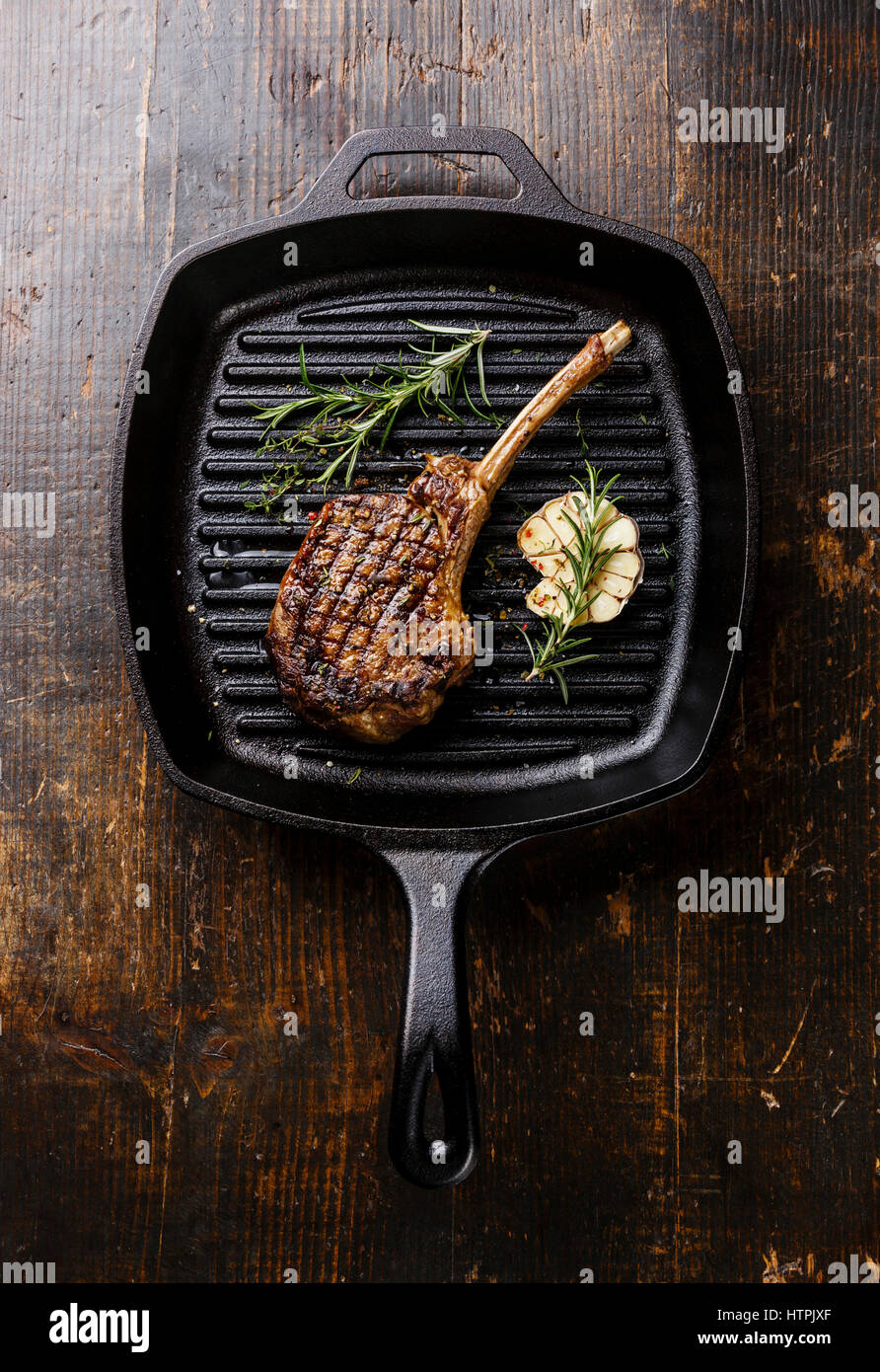 Grigliate di carne di vitello barbecue costola sulla frittura ghisa padella per grigliare su sfondo di legno Foto Stock