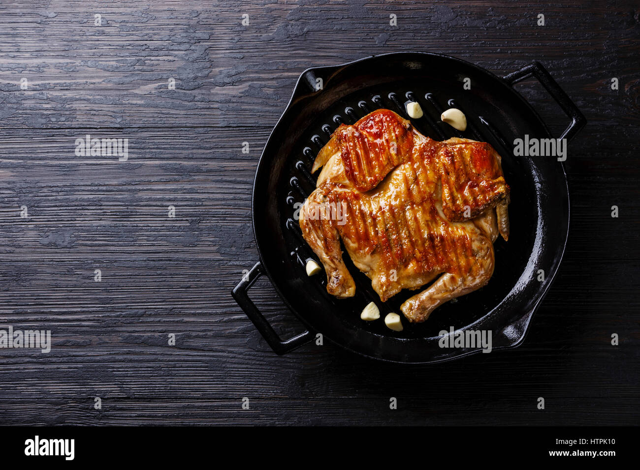 Grigliata di fritto di pollo arrosto Tabaka in padella su sfondo di legno spazio copia Foto Stock