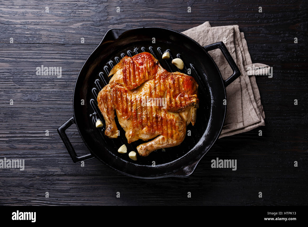 Grigliata di fritto di pollo arrosto Tabaka in padella su sfondo di legno Foto Stock