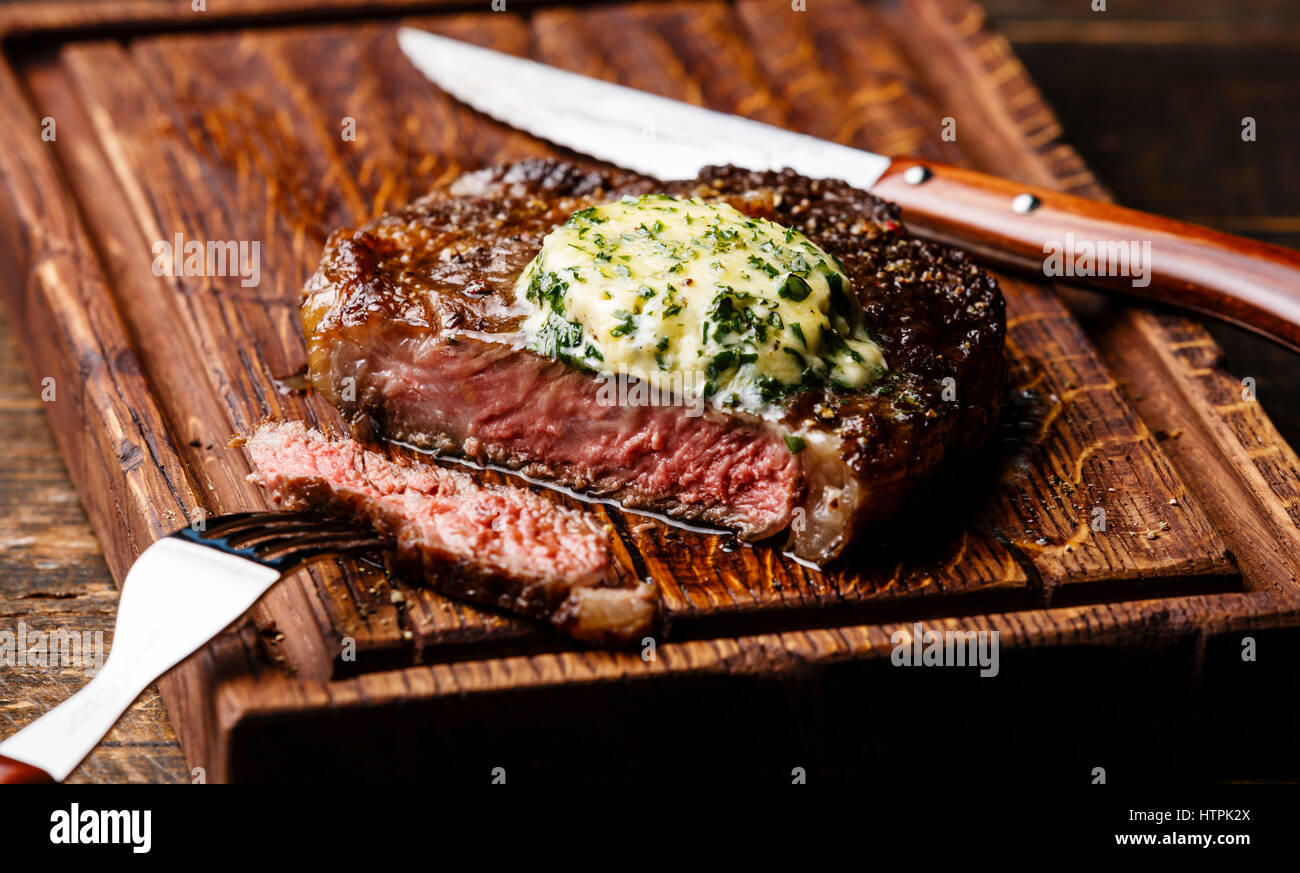 Grigliata di mezzo raro steak bistecca con burro alle erbe sul bordo di taglio serve dimensioni Foto Stock
