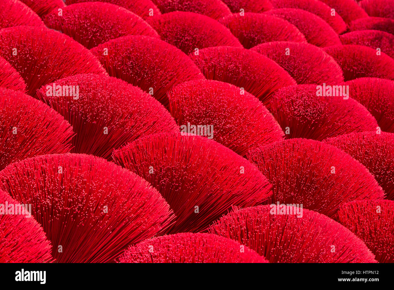 Rosso brillante Bamboo bastoncini di incenso di essiccazione, in preparazione della applicazione di incenso, lungo una provincia. Foto Stock