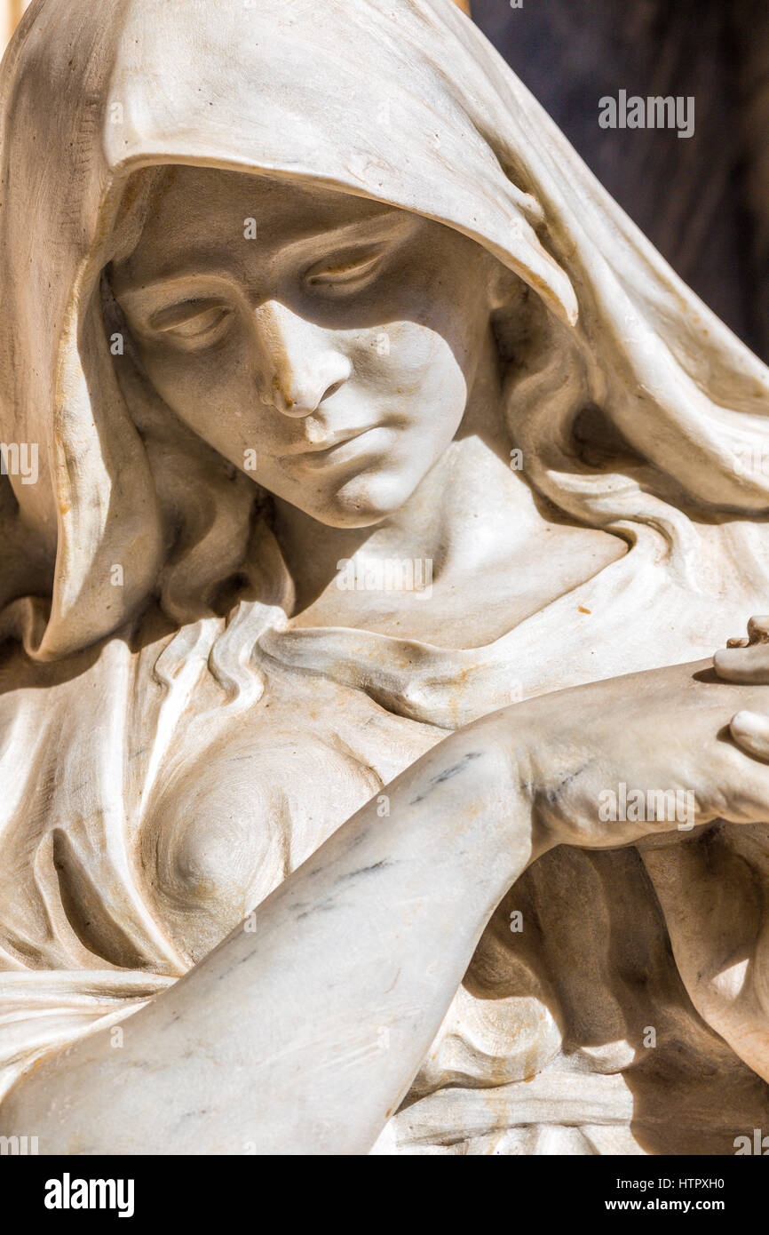 Statua di donna triste guardando in giù con la testa reclinata e mani unite in preghiera Foto Stock
