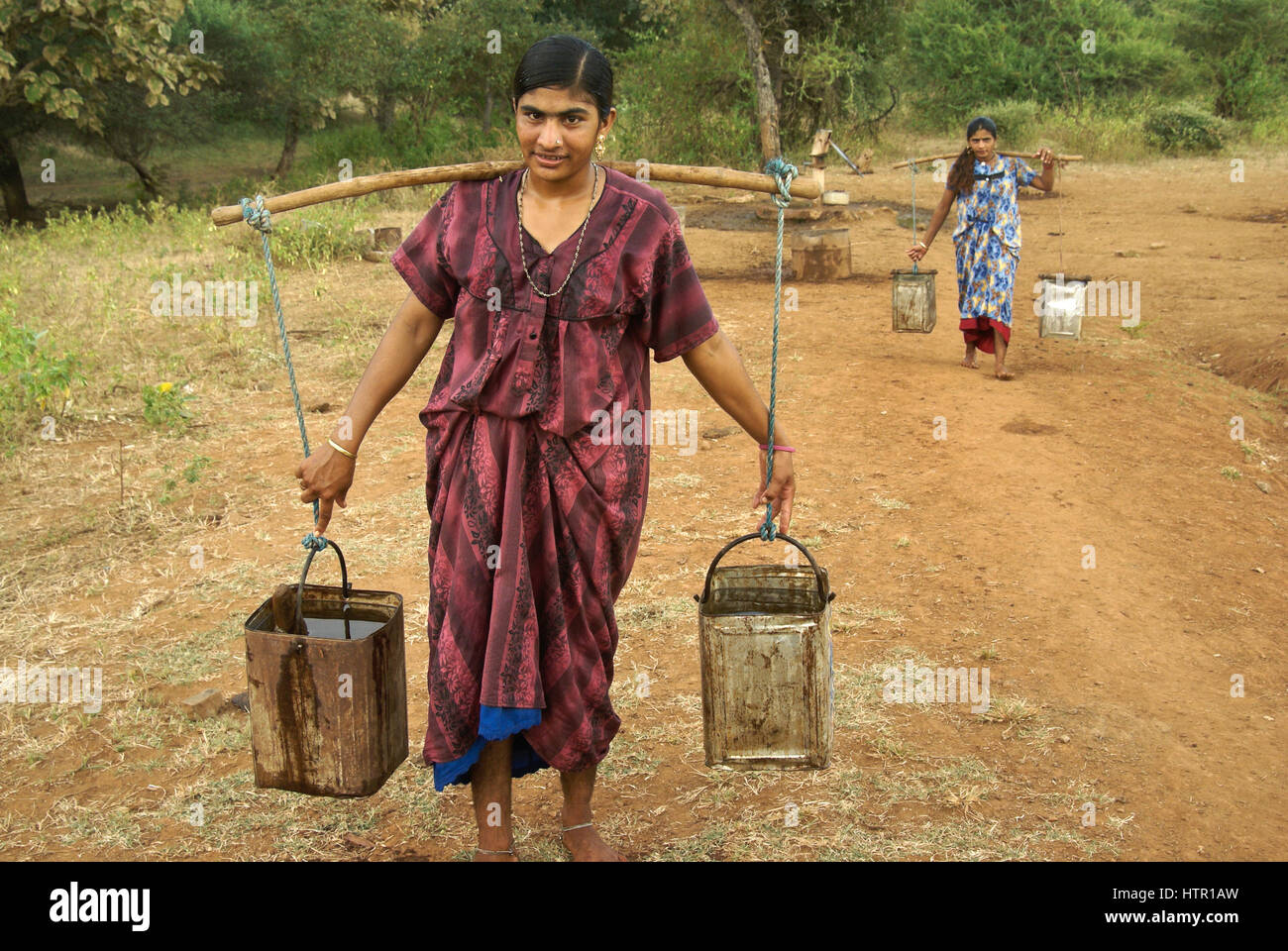 Ragazze Maldhari portando acqua dal pozzo, Sasan Gir (gir Forest), Gujarat, India Foto Stock