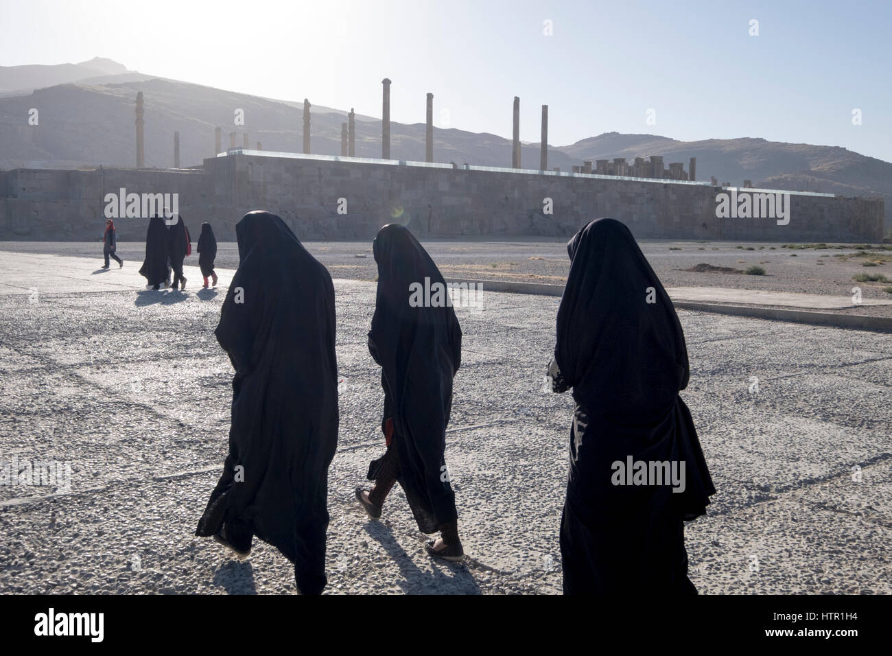 Rivestito di chador femmina testa di turisti verso le rovine della città antica di Persepolis, far Provincia, Iran. Foto Stock