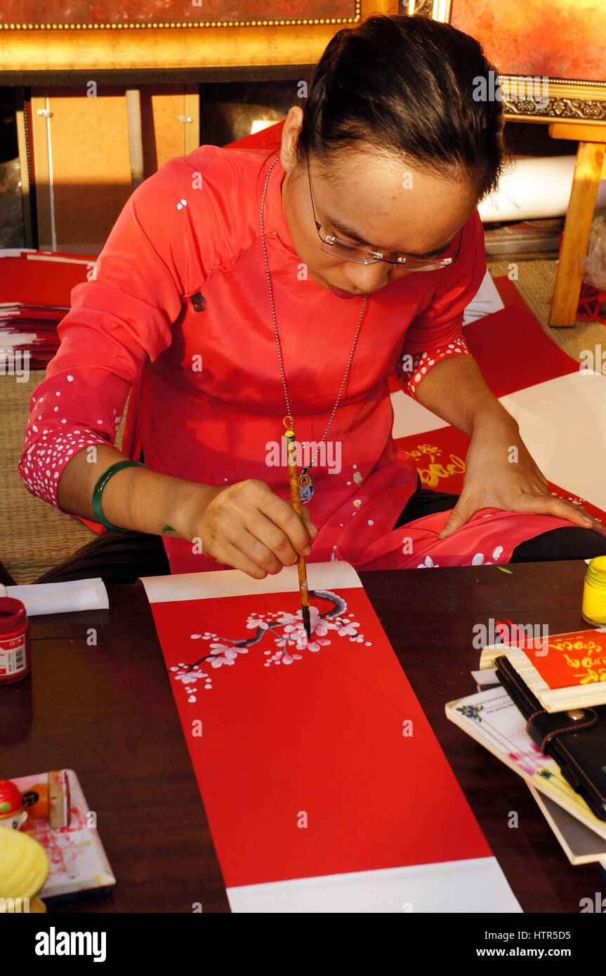 HO CHI MINH CITY, VIET NAM- FEB 7: atmosfera della primavera con colorati scena, donna vietnamita in ao dai, scrivere scrittura cinese o calligrafia Foto Stock