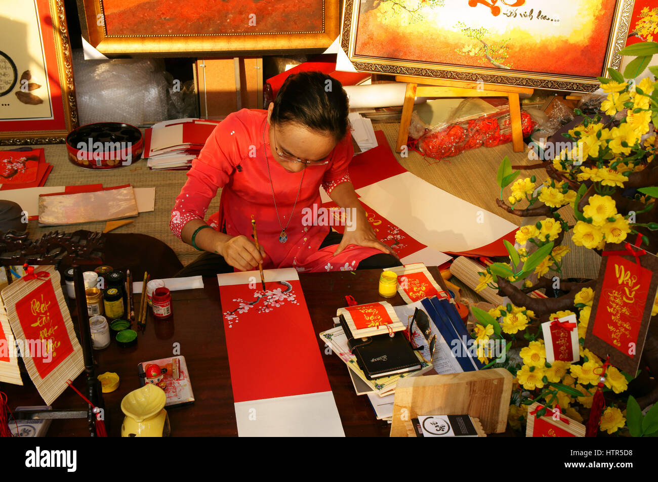 HO CHI MINH CITY, VIET NAM- FEB 7: atmosfera della primavera con colorati scena, donna vietnamita in ao dai, scrivere scrittura cinese o calligrafia Foto Stock