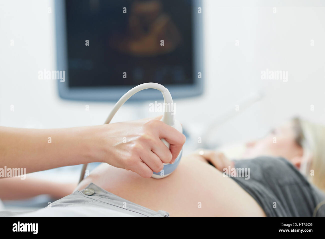 Medico utilizzando apparecchiature a ultrasuoni screening della donna incinta. Foto Stock