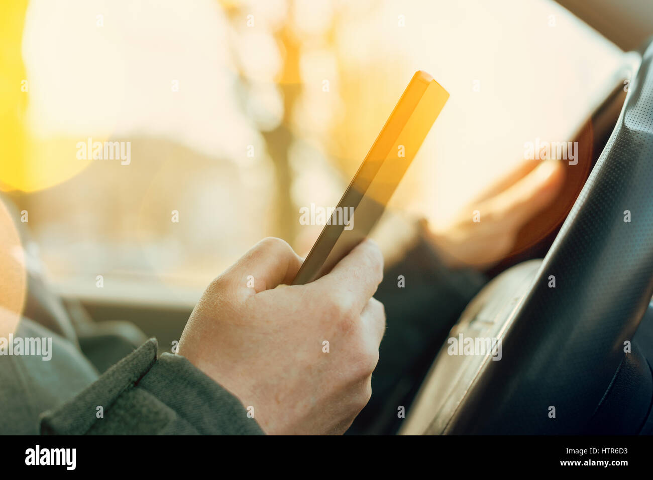 Temerario il comportamento del traffico, guida e utilizzando il telefono cellulare per inviare un messaggio SMS Foto Stock