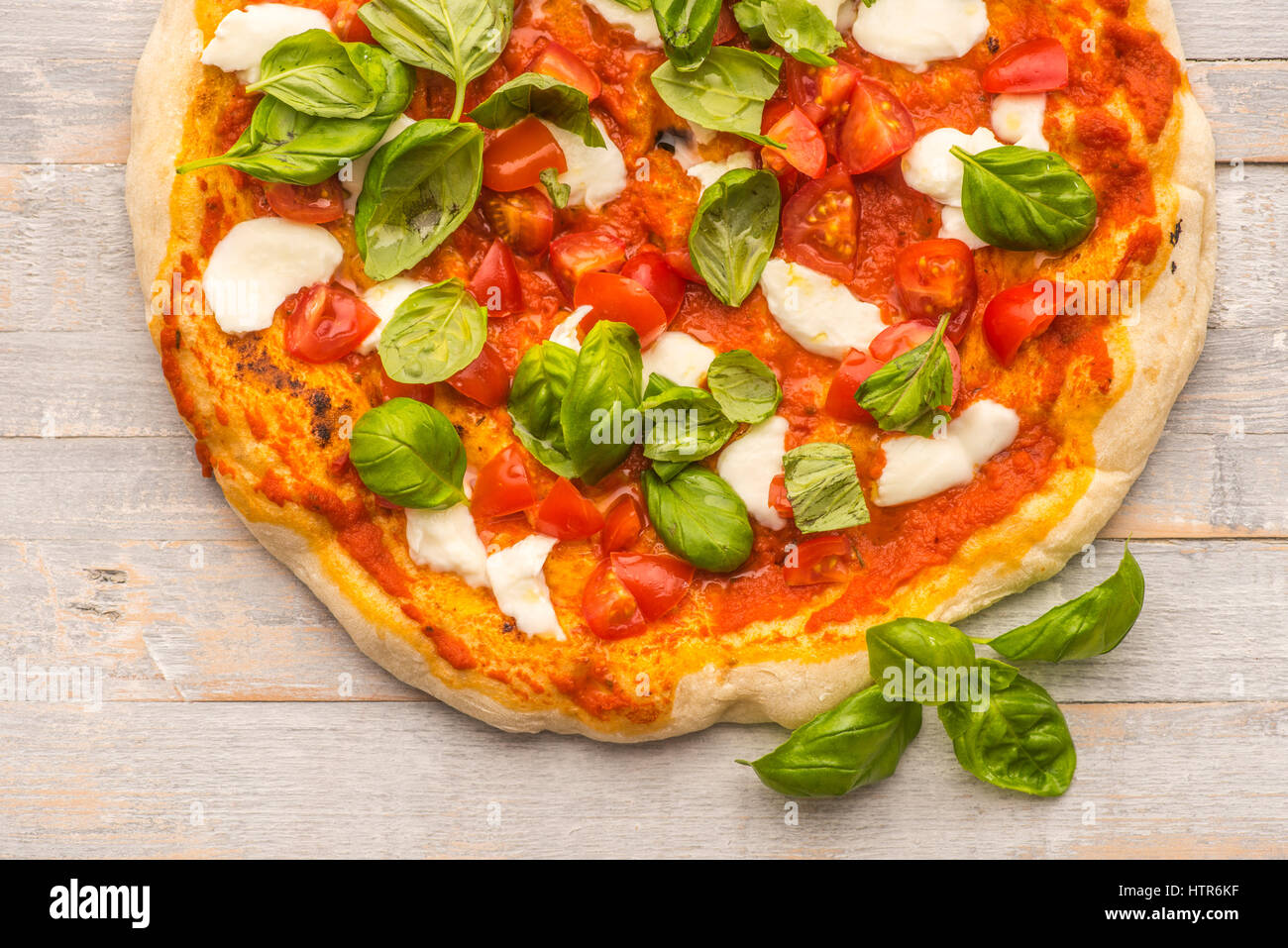 Fatto Feshly pizza al forno a legna visto dal di sopra su rustiche tavole grigio Foto Stock