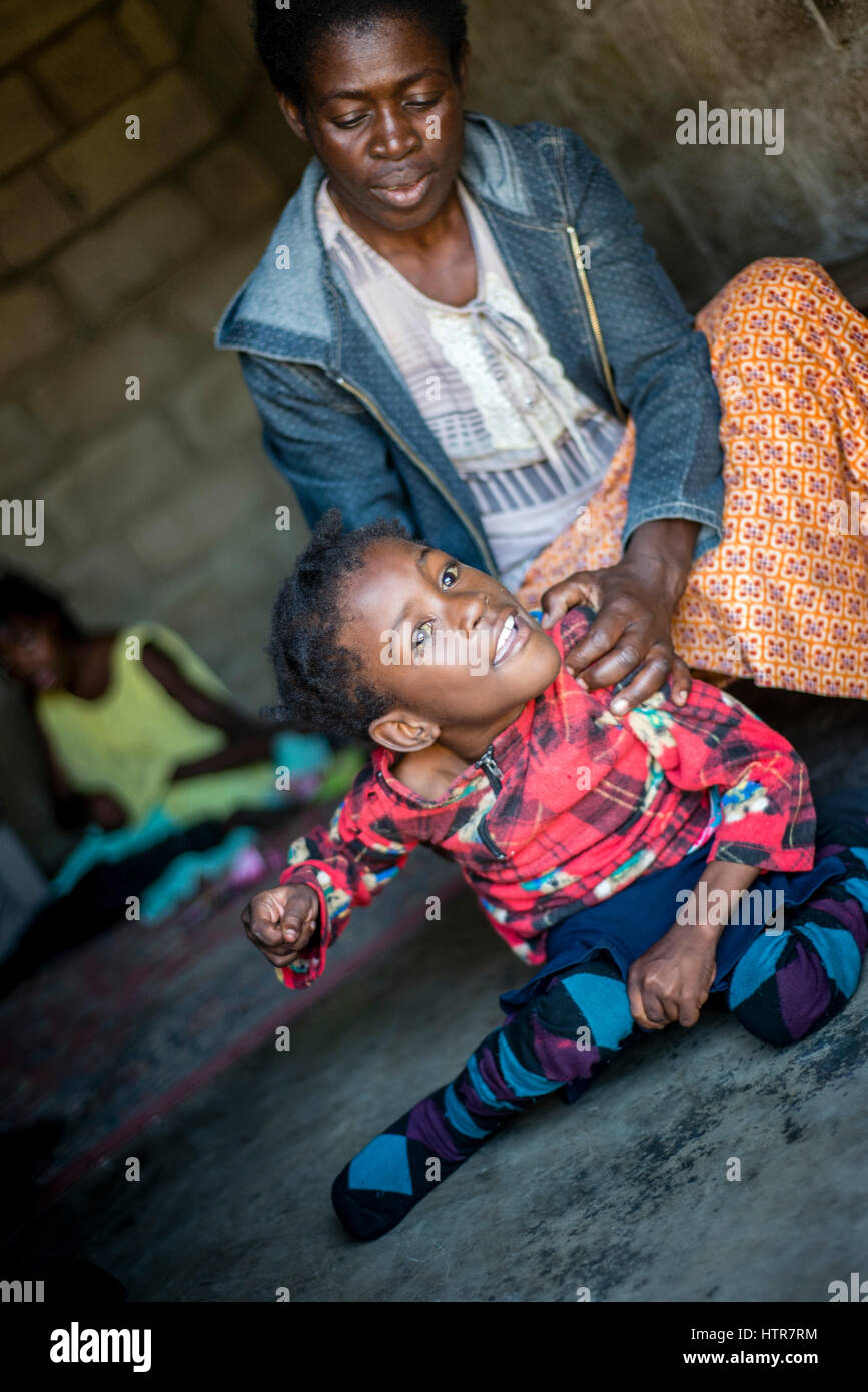 Volontari con i loro detenuti a casa di felicità per i bambini con disabilità a Lusaka, nello Zambia. Home della felicità è un orfanotrofio centro fondato nel 2015 da Bernadetta Mindeo. Ci sono 62 i bambini nel centro, 25 di loro vivono nella casa di felicità in modo permanente. Venti volontari si prendono cura dei ragazzi e ragazze con diversi tipi di disabilità. La casa della felicità è situato in due camere edificio senza eventuali strutture. I volontari di preparare il cibo sul fuoco, lavare l'abbigliamento infantile al di fuori. Foto Stock