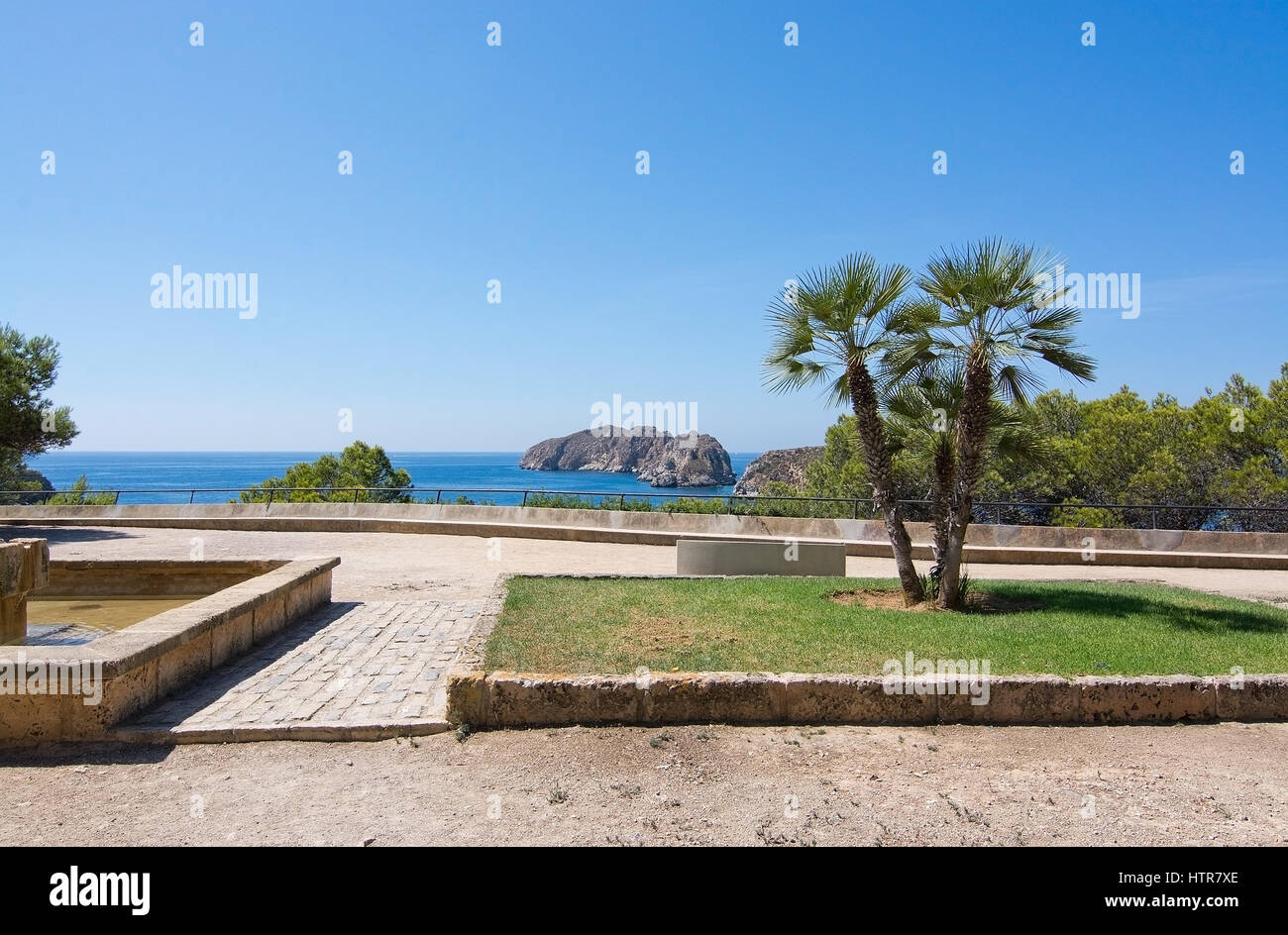 Le palme e la vista di Islas Malgrats su una soleggiata giornata estiva in Santa Ponsa, Maiorca, isole Baleari, Spagna. Foto Stock