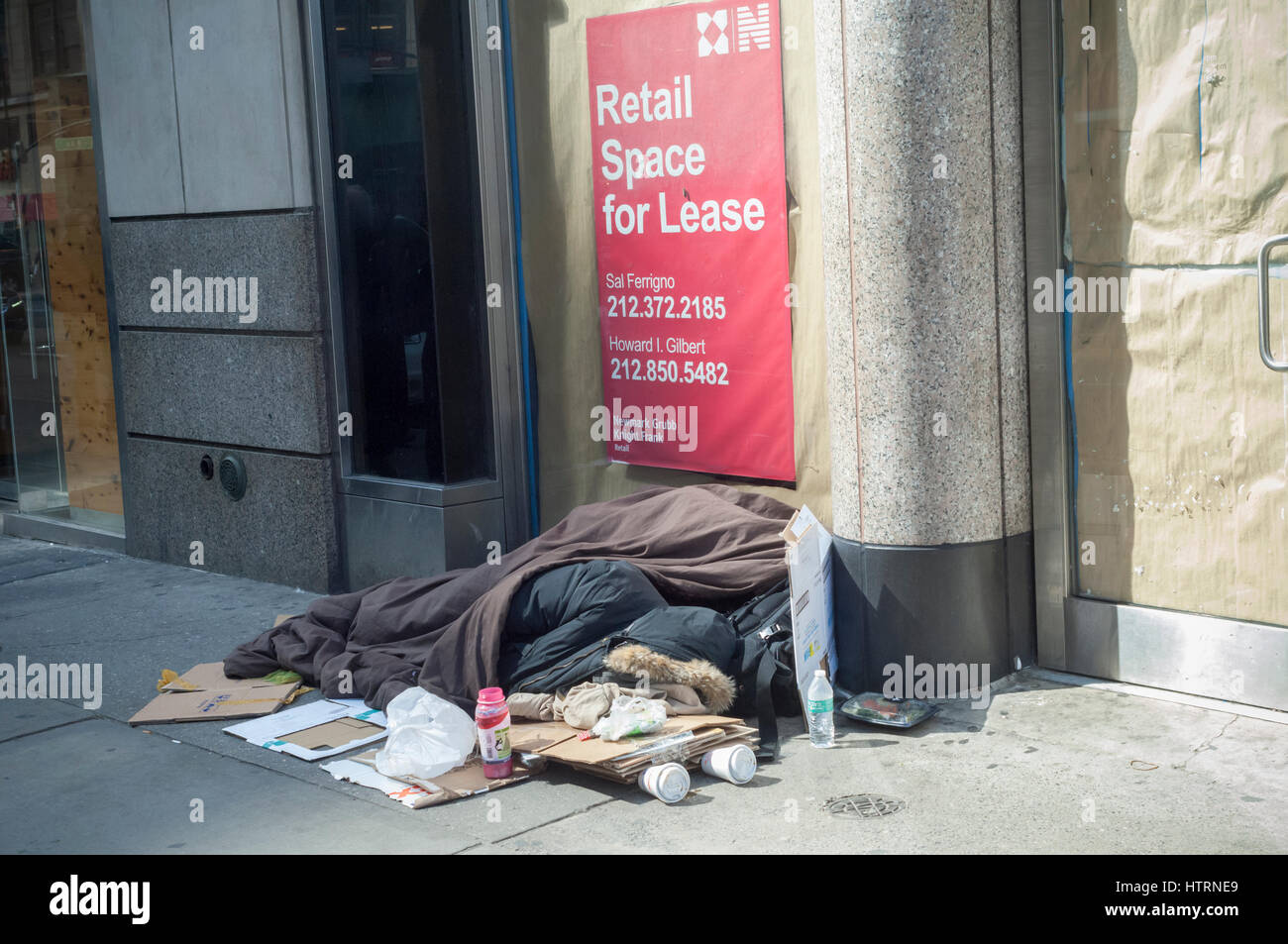 Un senzatetto singoli dorme nella parte anteriore di un vacante in vetrina a New York Sabato, 11 marzo 2017. (© Richard B. Levine) Foto Stock