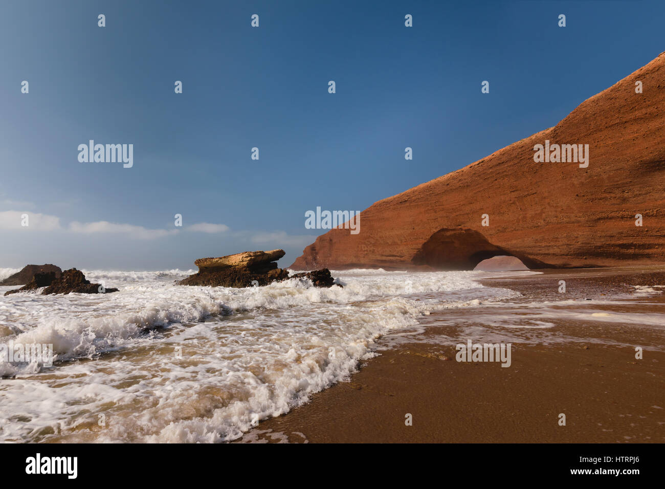 Archi in rosso e la spiaggia rocciosa e all'Oceano Atlantico nella regione Sous-Massa-Draa, Sidi Ifni, Legzira, Marocco, Africa. Foto Stock