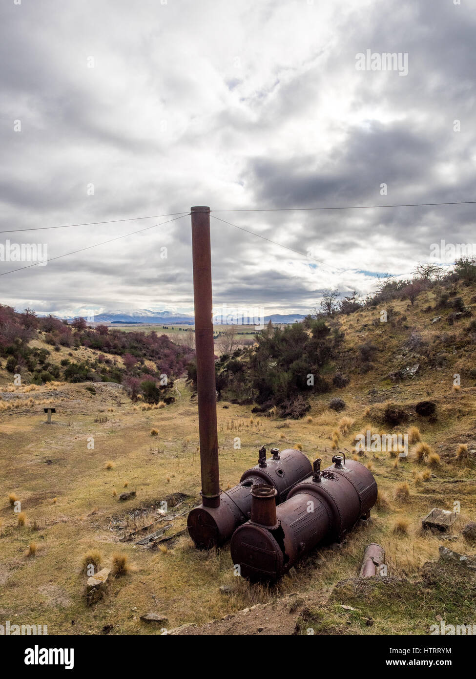 Golden progressi miniera di quarzo, Oturehua, Manitoto di Central Otago, Nuova Zelanda. Viste della caldaia abbandonati e la testa della valvola a fungo. Foto Stock