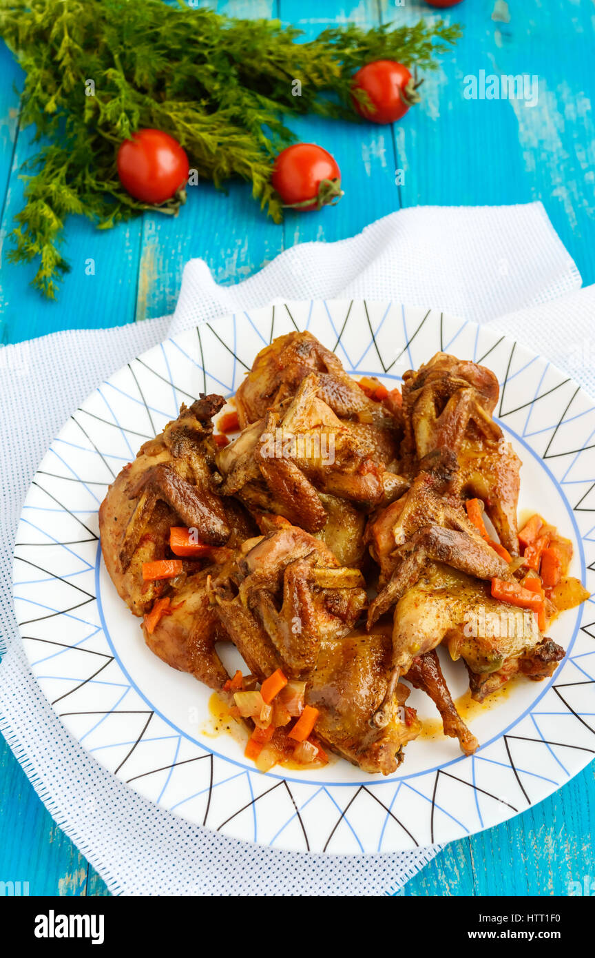 Stufato di quaglia con salsa di verdure su un blu tavolo in legno. Close up Foto Stock