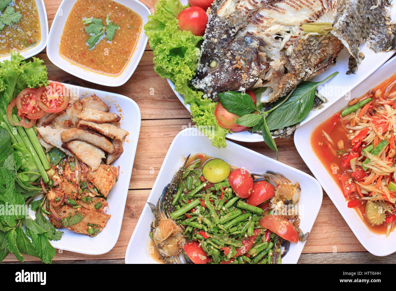 Raccolta di cibo tailandese sul pavimento in legno,l'insalata di papaia (SOM TUM),piccante di carne di maiale alla griglia, insalate e grigliate di pesce nel cibo è stato popolare in Thailandia. Foto Stock