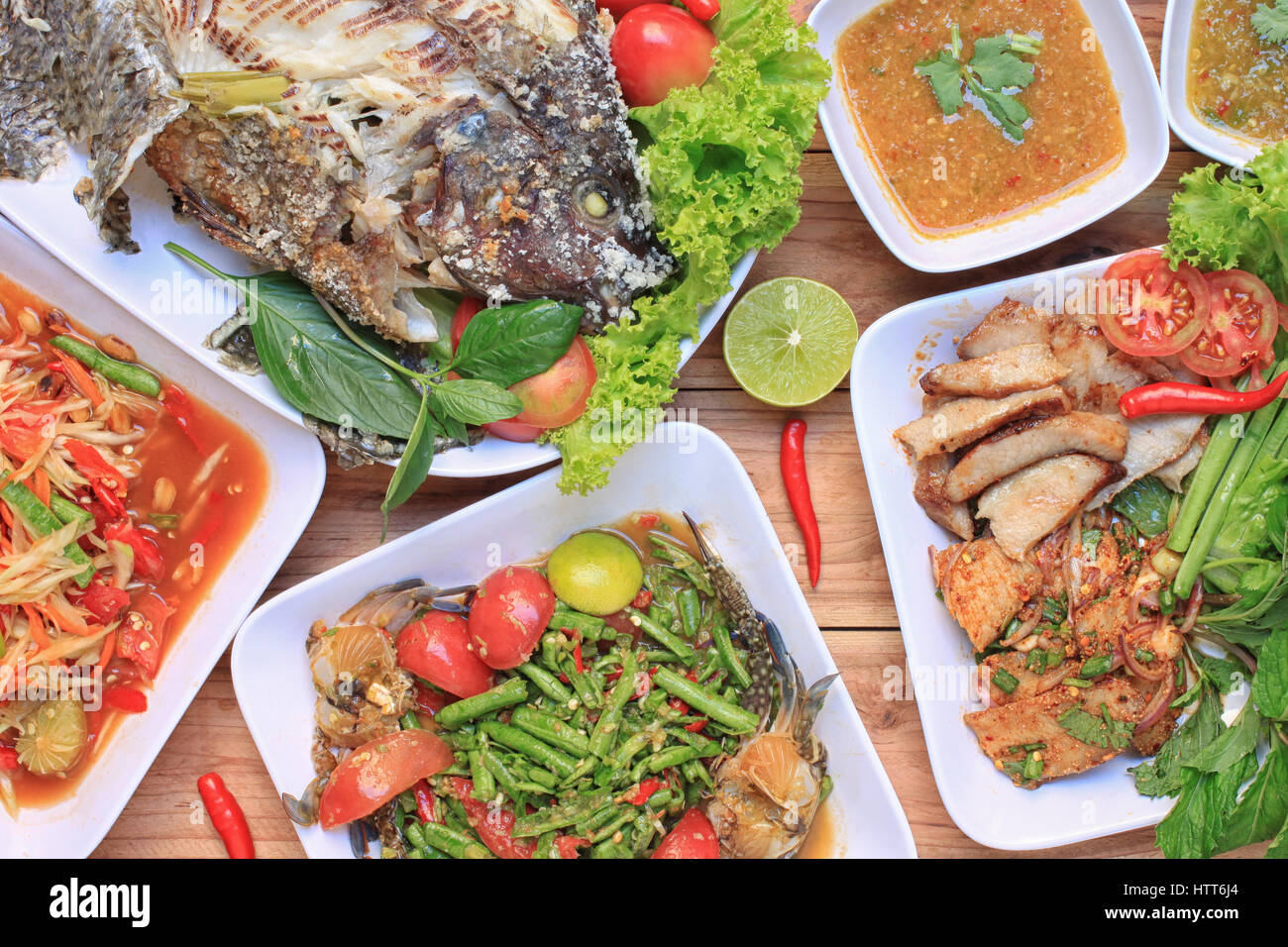 Raccolta di cibo tailandese sul pavimento in legno,l'insalata di papaia (SOM TUM),piccante di carne di maiale alla griglia, insalate e grigliate di pesce nel cibo è stato popolare in Thailandia. Foto Stock