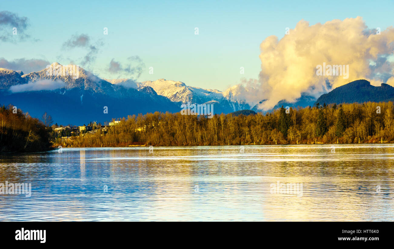 Lo splendido paesaggio del fiume Fraser con il bianco innevate montagne costiere come una discesa in Fort Langley, British Columbia, Canada Foto Stock