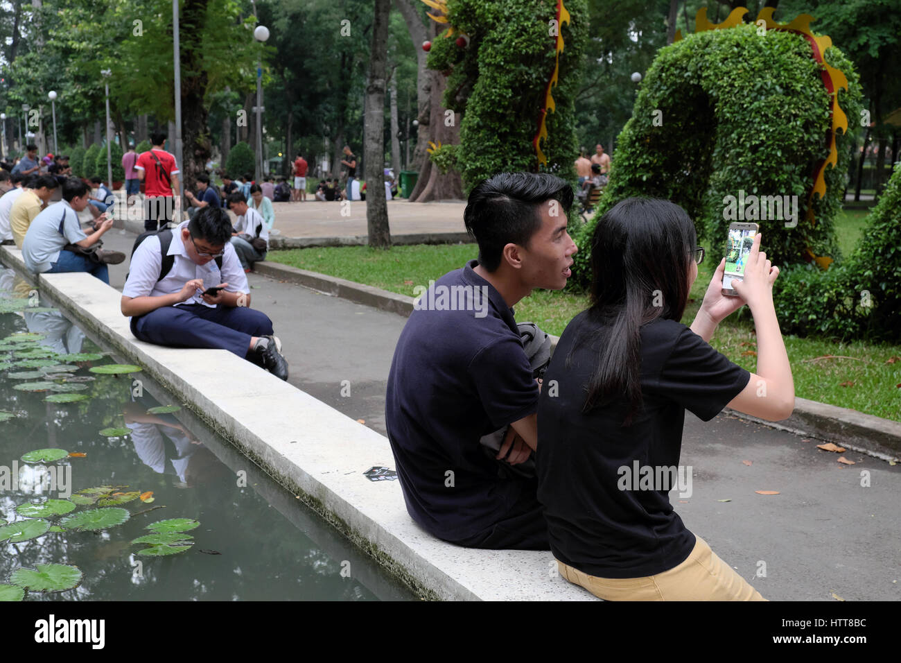 HO CHI MINH CITY, VIET NAM- Agosto 20, 2016: Giovani asiatici giovane Gioca Pokemon andare insieme su smart phone a Tao Dan park, Ho Chi Minh City, Vietnam Foto Stock
