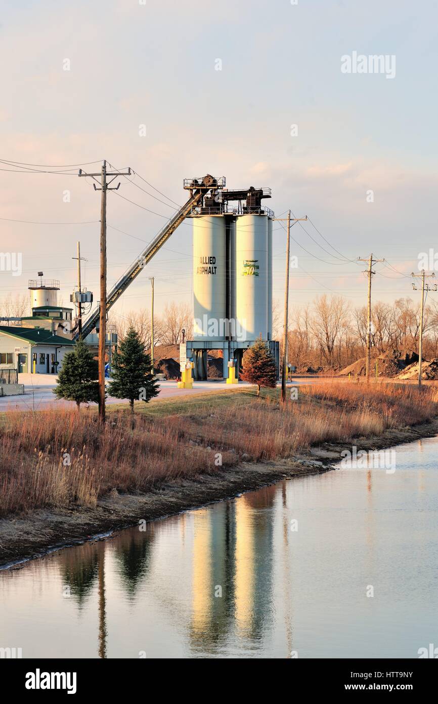 I serbatoi di stoccaggio in corrispondenza di un asfalto azienda di produzione in un ambiente industriale nei pressi di un laghetto di ritenzione nel sobborgo di Chicago di Bartlett, Illinois.USA. Foto Stock