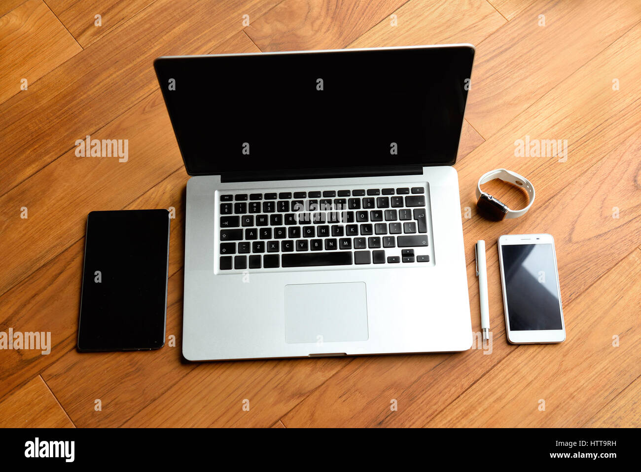 Office stuff con notepad, laptop, smartphone, penna e guardare sul brown scrivania in legno. Vista da sopra con copia spazio. Foto Stock