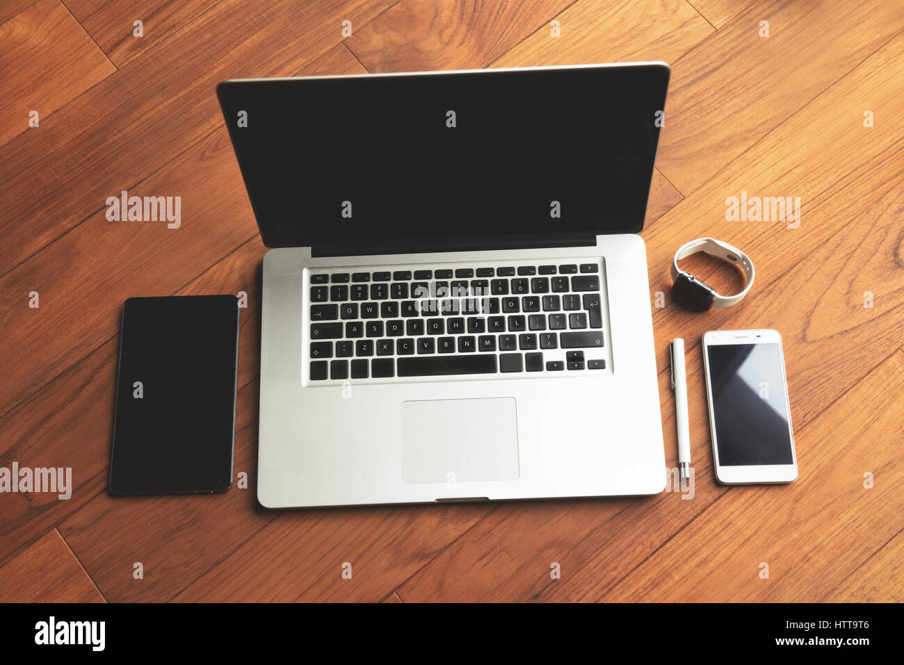 Office stuff con notepad, laptop, smartphone, penna e guardare sul brown scrivania in legno. Vista da sopra con copia spazio. Foto Stock
