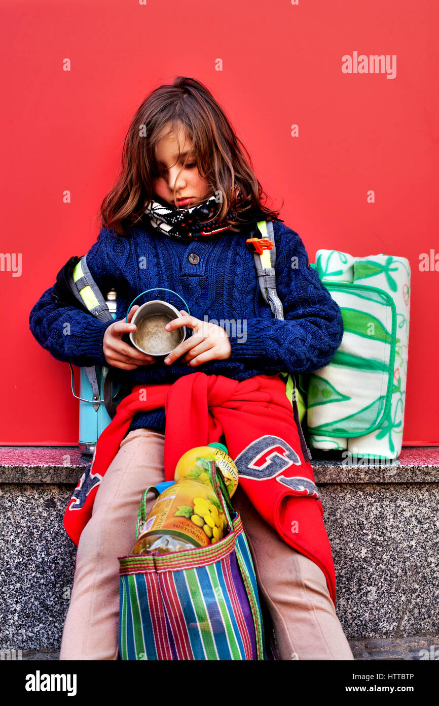 Molto buona cerchi di 8 anni in attesa presso la fermata degli autobus per andare su una molla picnic, Barcelona, Spagna. Foto Stock