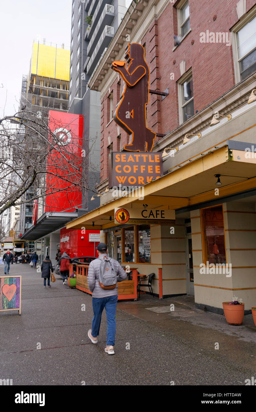 Uomo che cammina oltre la Seattle opere caffè coffee shop segno nel centro cittadino di Seattle, Washington, Stati Uniti d'America Foto Stock