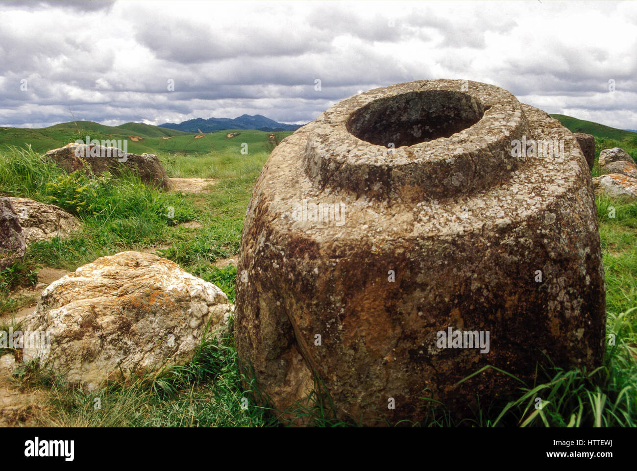 Antica urne di pietra a Thong Hai Hin sulla pianura di giare, un paesaggio segnato dai crateri di bombe e mine inesplose. Xieng Khouang Provincia, Laos Foto Stock