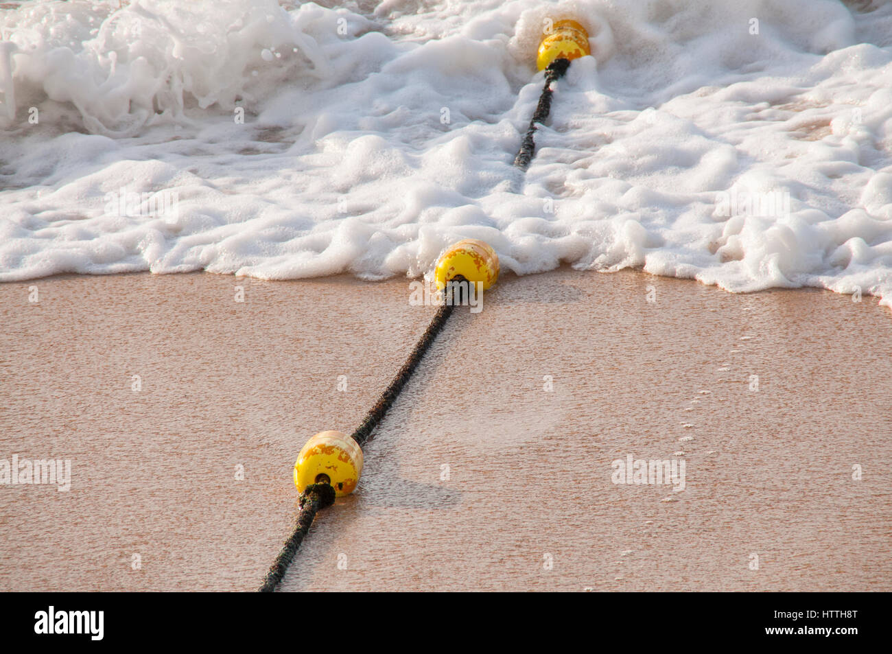 Boe di colore giallo sulla corda Dividi area piscina sulla spiaggia Foto Stock