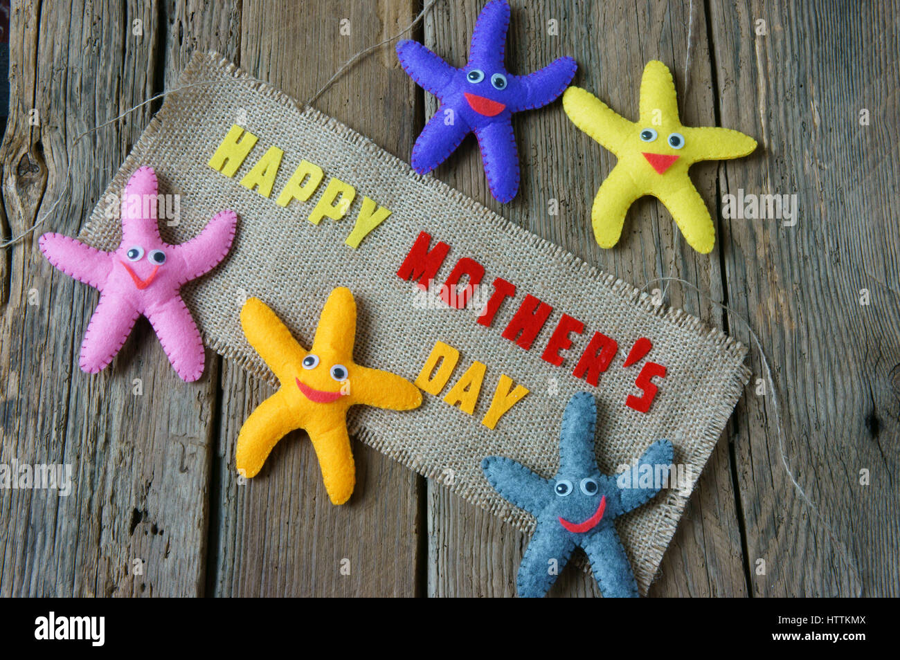 Felice Festa della mamma con ti amo mamma messaggio, idea dal tessuto colorato starfish su sfondo di legno, bel fiore, abstract texture di legno, Foto Stock