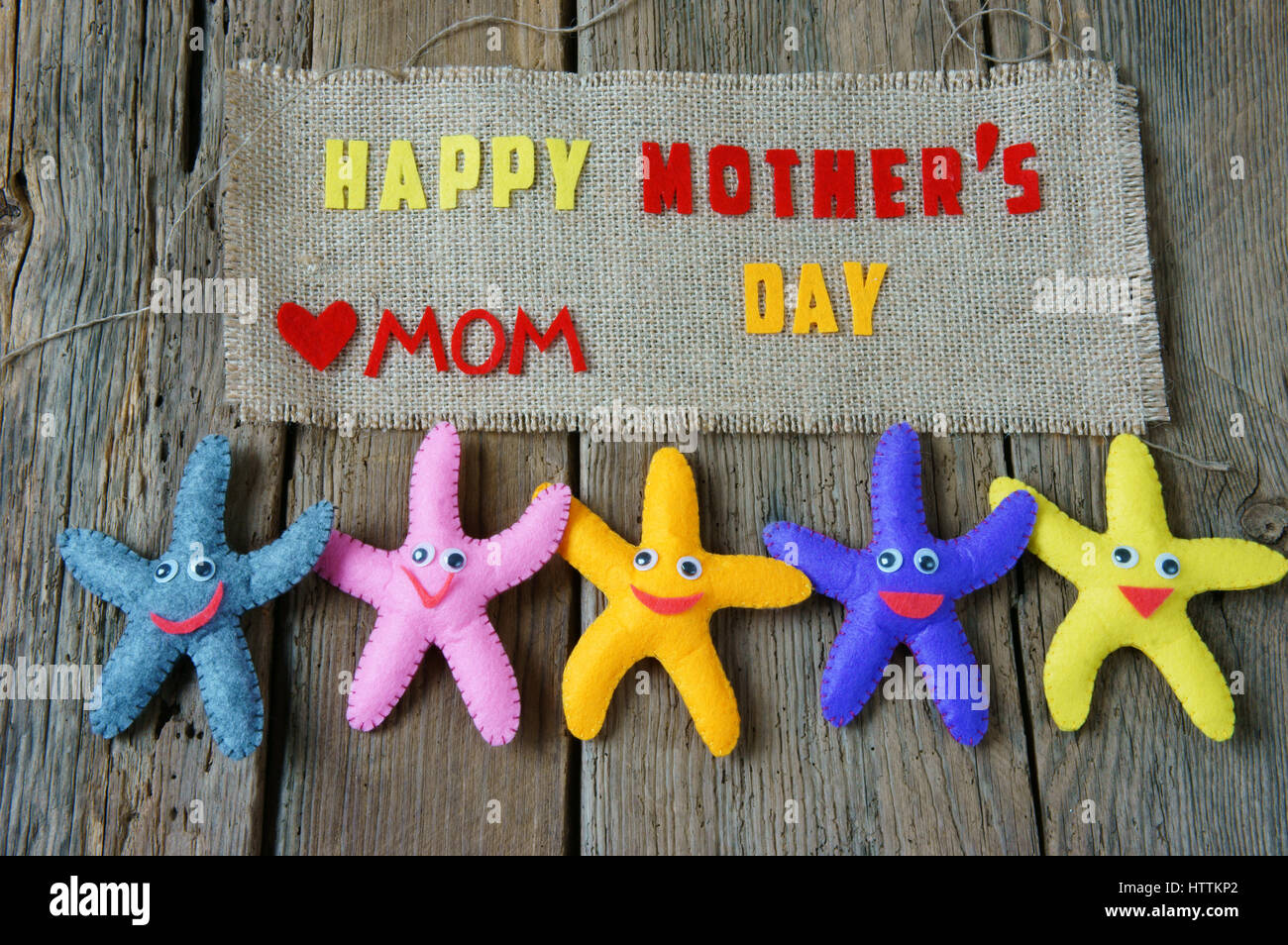 Felice Festa della mamma con ti amo mamma messaggio, idea dal tessuto colorato starfish su sfondo di legno, bel fiore, abstract texture di legno, Foto Stock