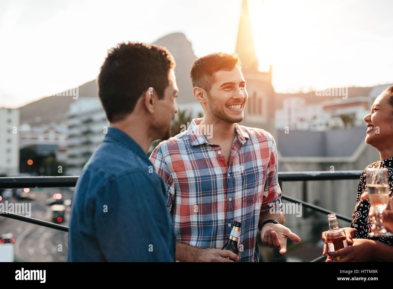 Un gruppo di giovani felici hanno avente una parte sul tetto. Gli amici sorseggiando party con bevande. Foto Stock Un gruppo di giovani felici hanno avente una parte sul tetto. Gli amici sorseggiando party con bevande. Foto Stock