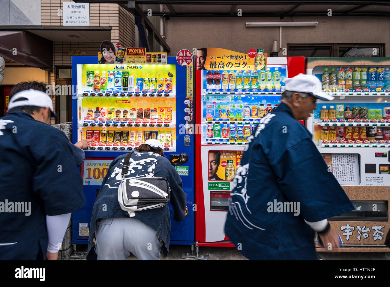 Giapponese uomini di mezza età bevande di acquisto da un distributore automatico, Kyoto, Giappone Foto Stock