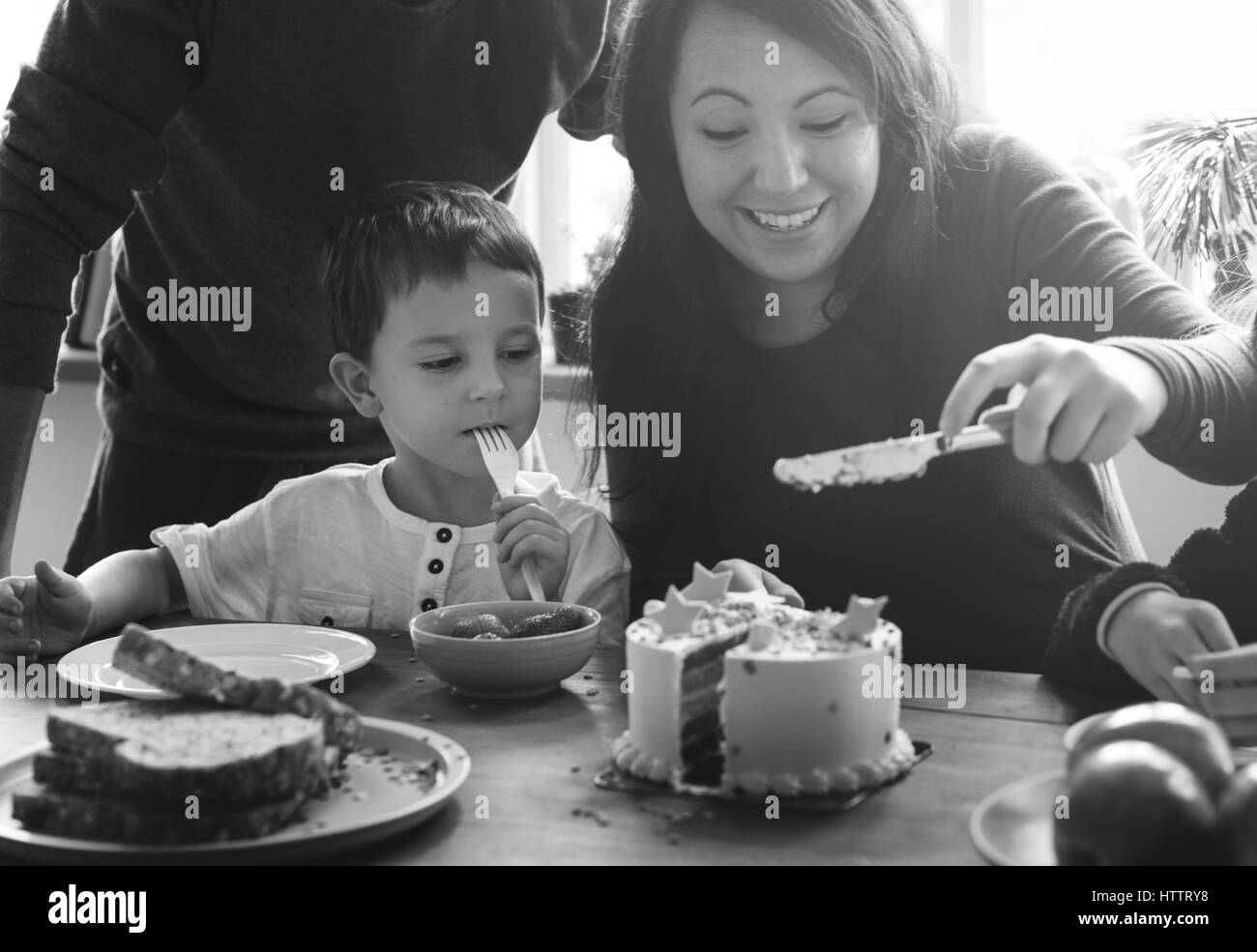 Famiglia festeggia il compleanno torta sorriso felice Foto Stock