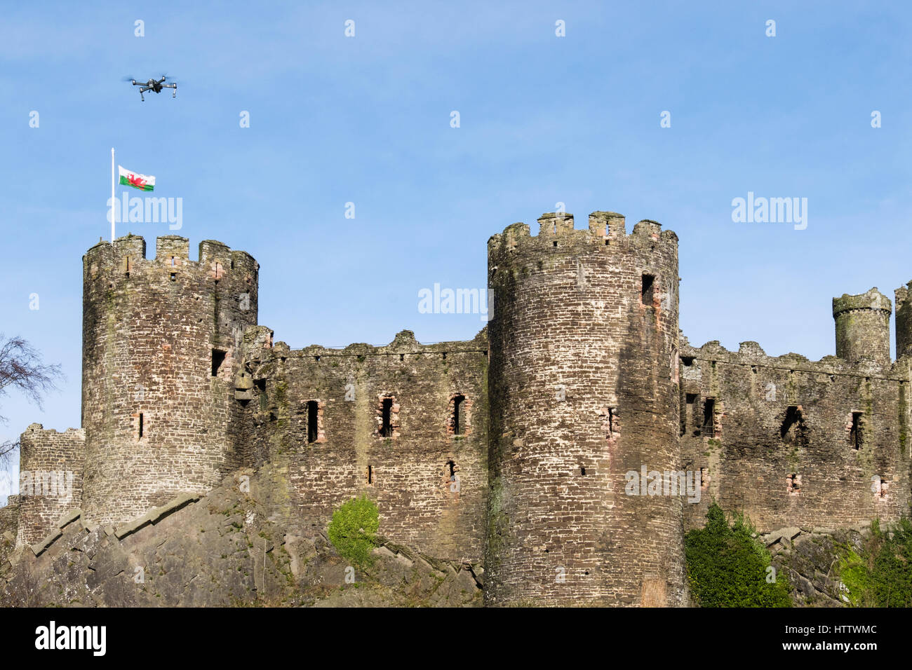 Conwy Castle con bandiera gallese e piccolo drone volare al di sopra. Conwy, Wales, Regno Unito, Gran Bretagna, Europa Foto Stock