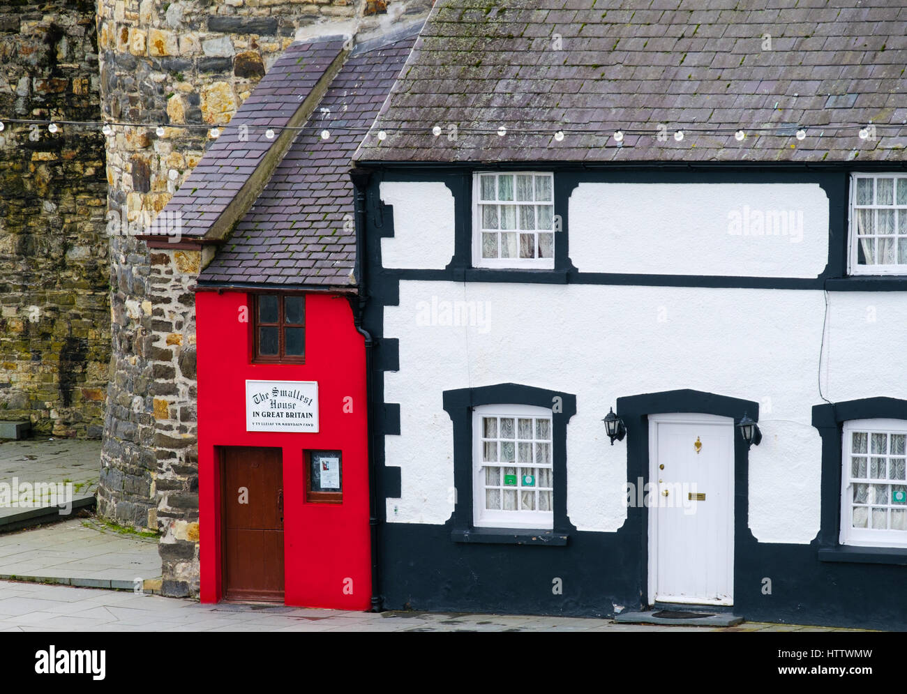 Piccolo rosso Quay House è la più piccola casa in Gran Bretagna con le mura della città sulla banchina a Conwy, Wales, Regno Unito, Gran Bretagna Foto Stock