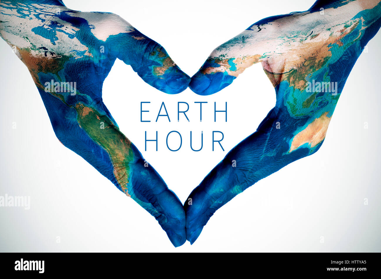 Il testo ora della terra e le mani di una giovane donna, modellato con una mappa del mondo (arredata dalla NASA), formando un cuore Foto Stock