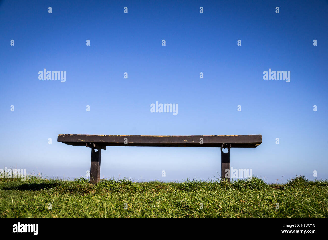 Panca su erba verde con panca wit di cielo blu chiaro sfondo Foto Stock