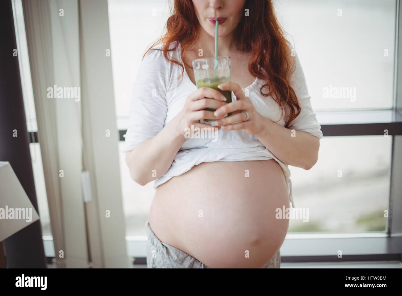 Donna incinta di bere succo di frutta Foto Stock