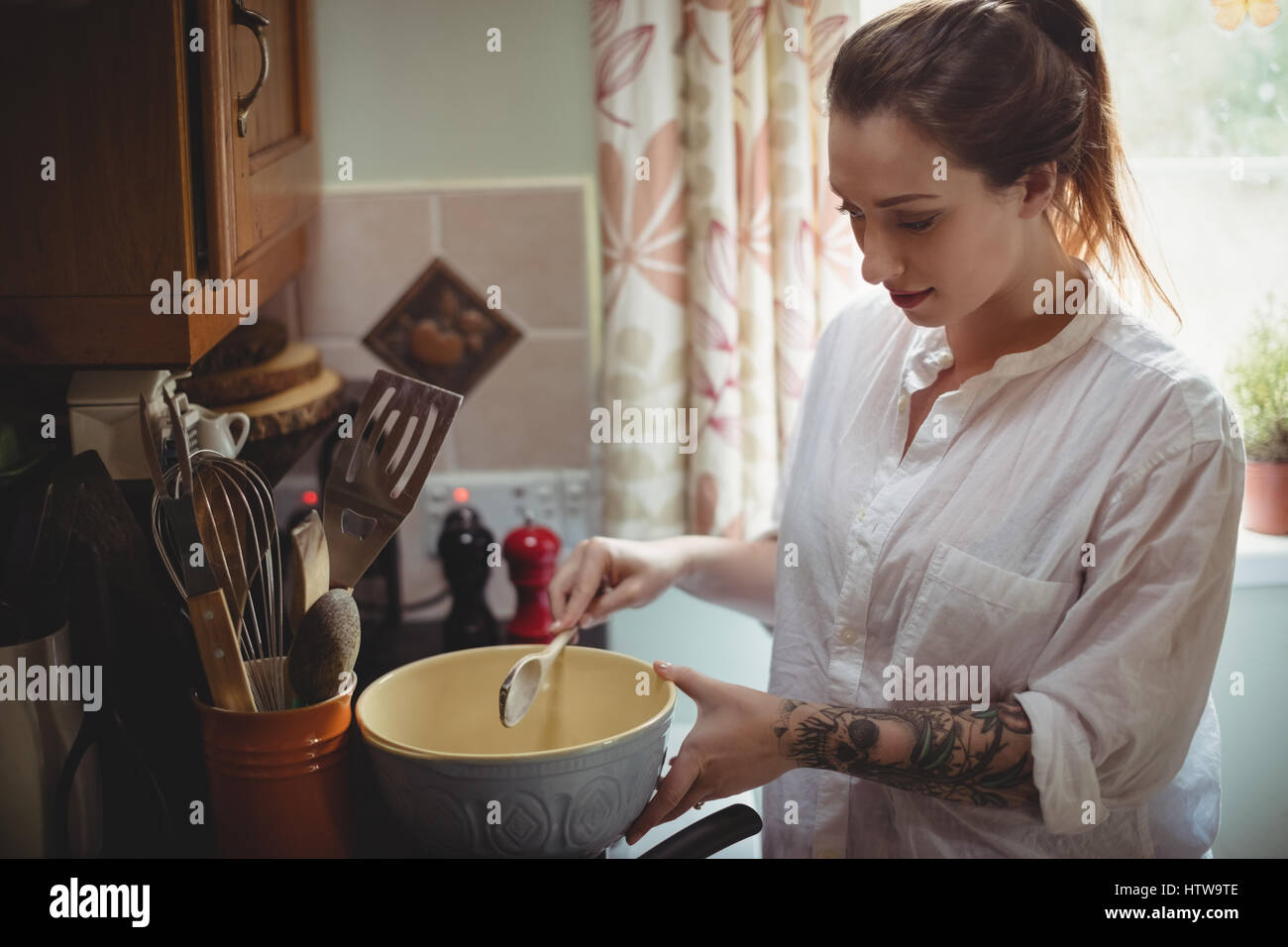 Donna in piedi e preparazione di pasto in cucina Foto Stock